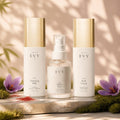 The Essentials Ritual: N° 01 Cleansing Milk, N° 02 Saffron Mist and N° 05 Rich Cream on a stone slab with moss and saffron crocus in warm sunlight