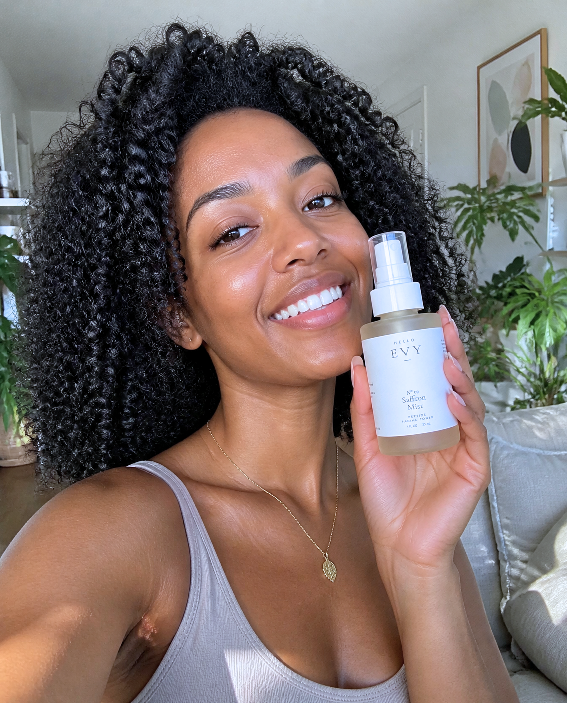 Customer with glowing skin holding Hello Evy No. 02 Saffron Mist toner